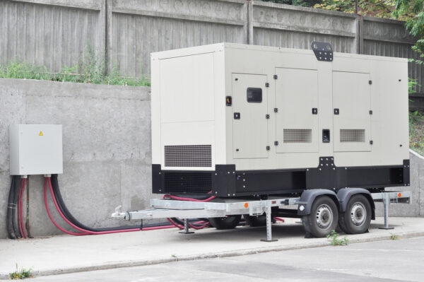 Industrial Diesel Generator. Standby generator. Industrial Diesel Generator for Office Building connected to the Control Panel with Cable Wire. Backup Generator Power.